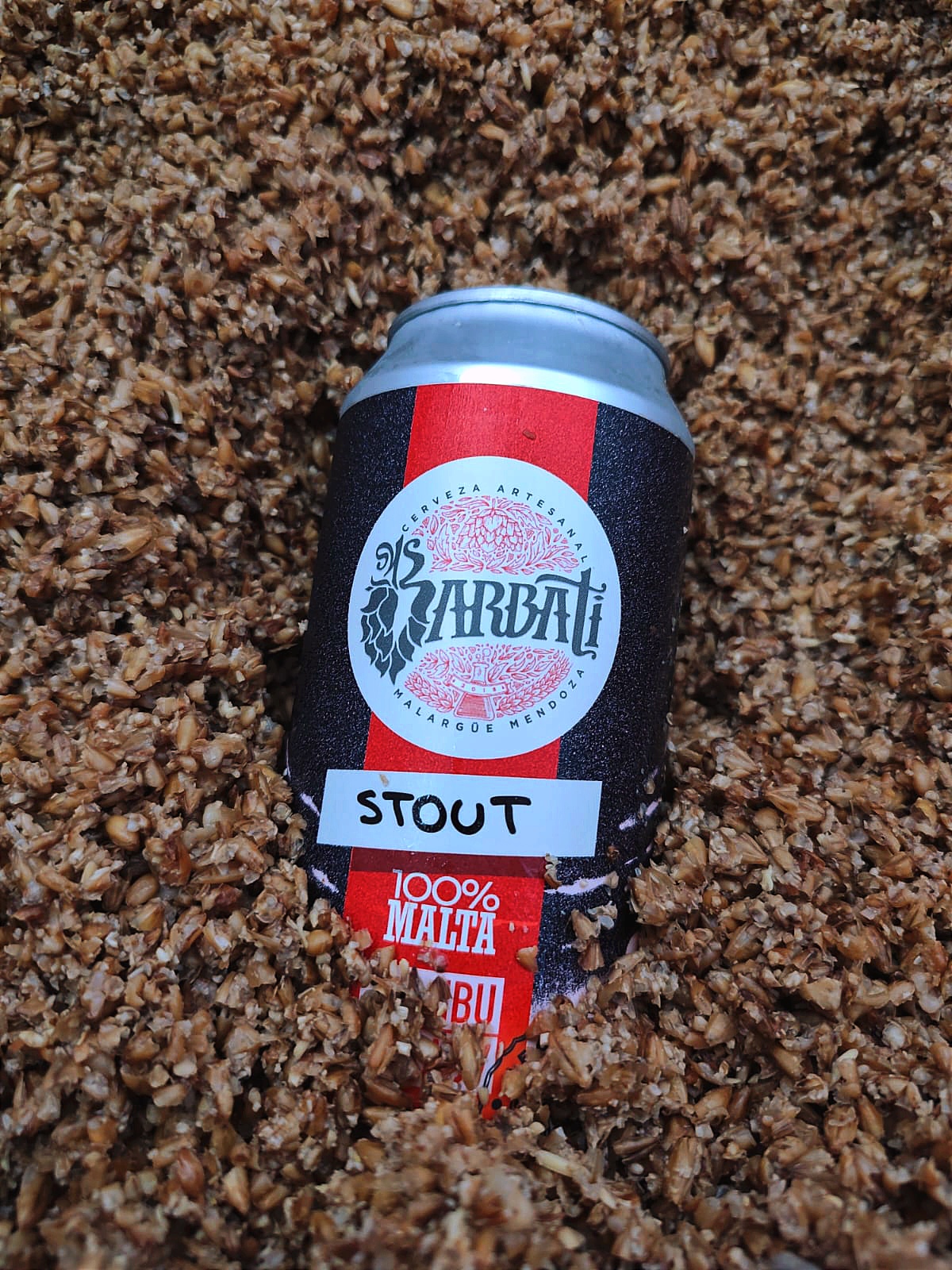 Lata de Barbati Stout sobre granos de malta tostada
